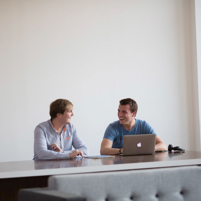 Two students sitting at a desk with laptop