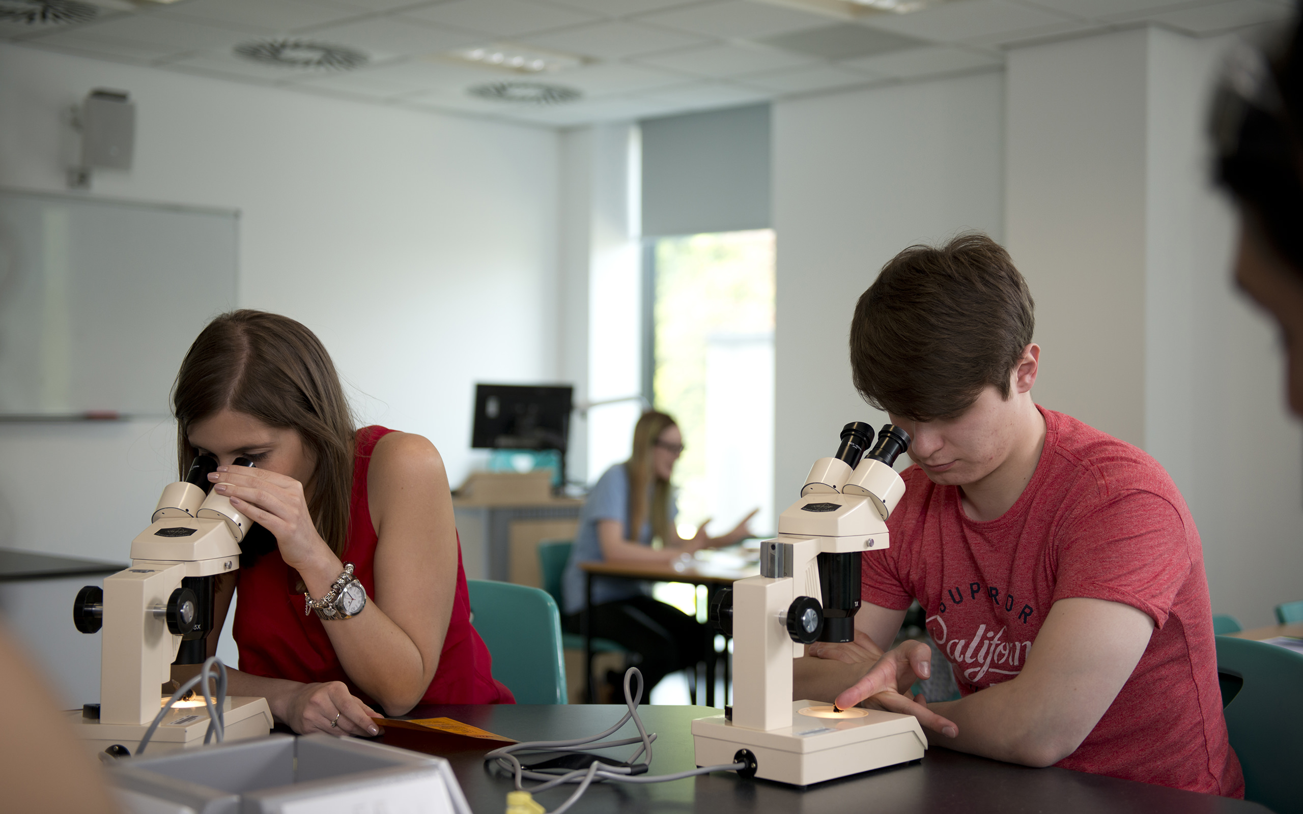 Two students using microscopes