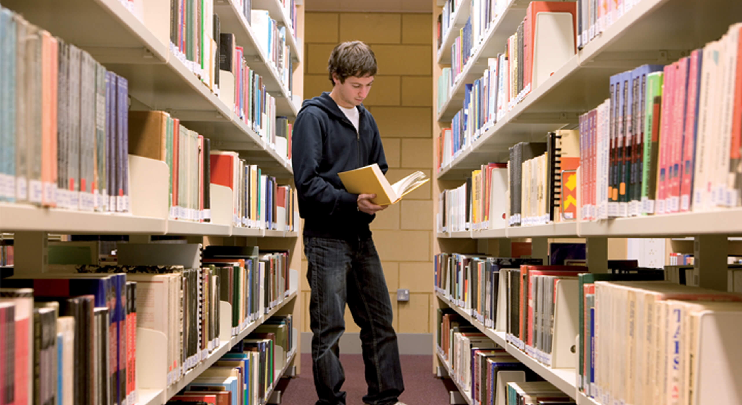Childhood studies | male in library browsing books