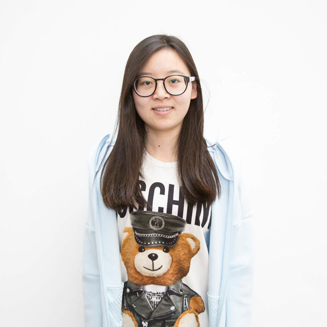 Female student with glasses standing white background