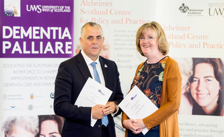 Two people in front of Dementia Alzheimer Policy and Practice banner 