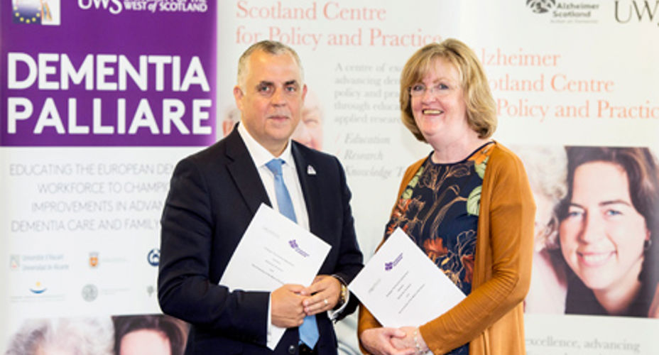 Two people in front of Dementia Alzheimer Policy and Practice banner