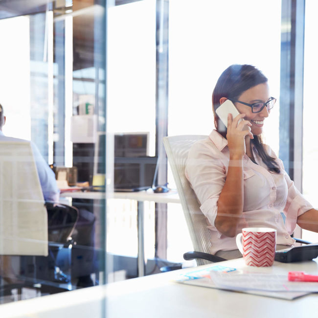 Female on phone while sitting at a desk