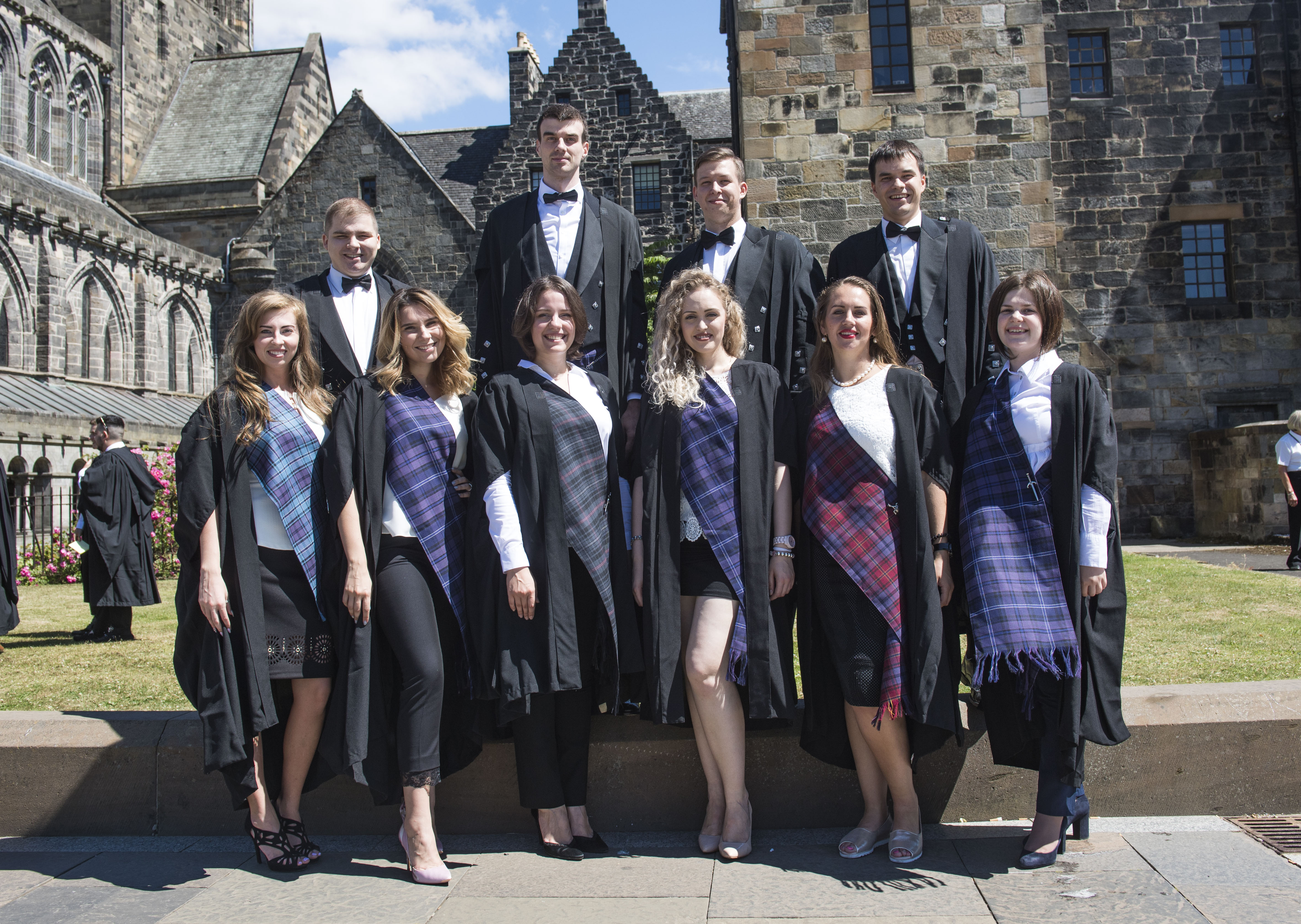 Group of students in graduation gowns with tartan shawls