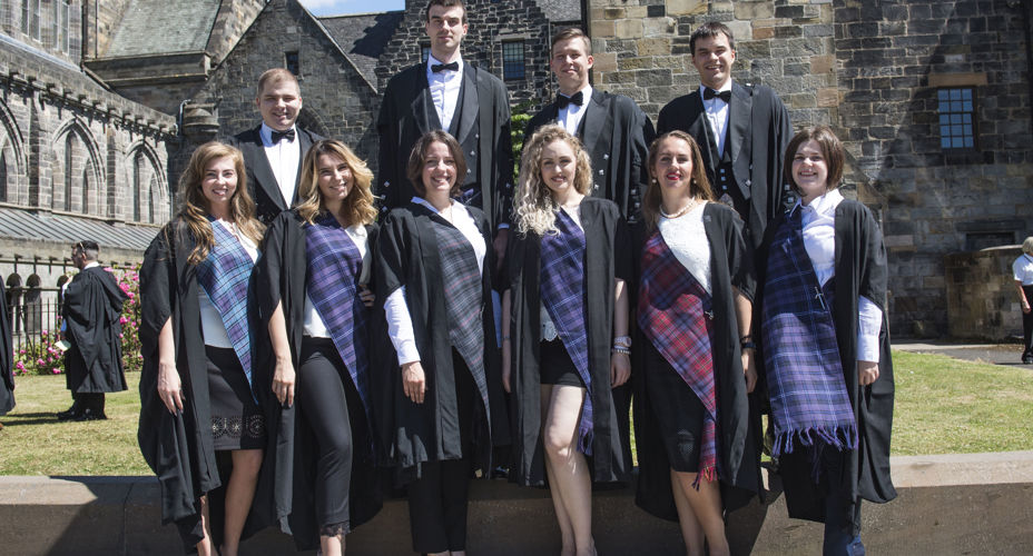 Group of students in graduation gowns with tartan shawls