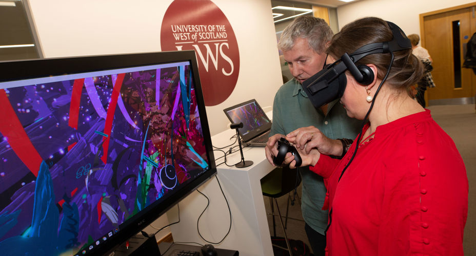 Person trying VR headset with member of staff