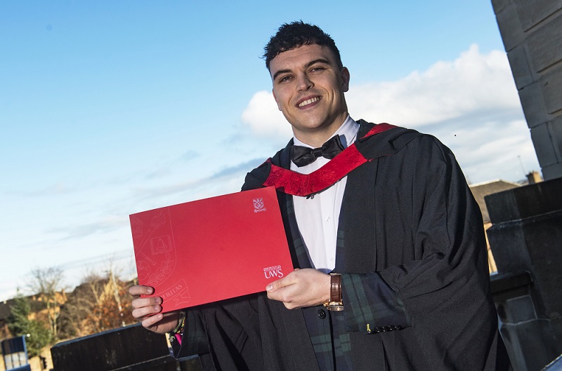 Graduate holding certificate in Graduation robes 
