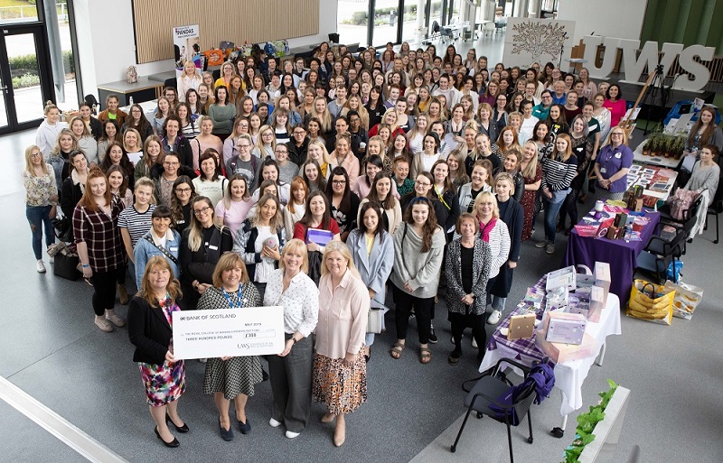 Midwifery staff and students holding giant cheque