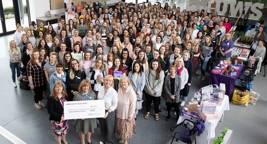 Midwifery staff and students holding giant cheque