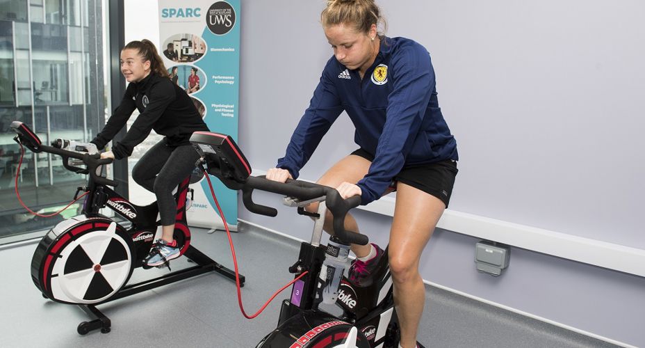Christie Murray And Sophie Howard on exercise bikes