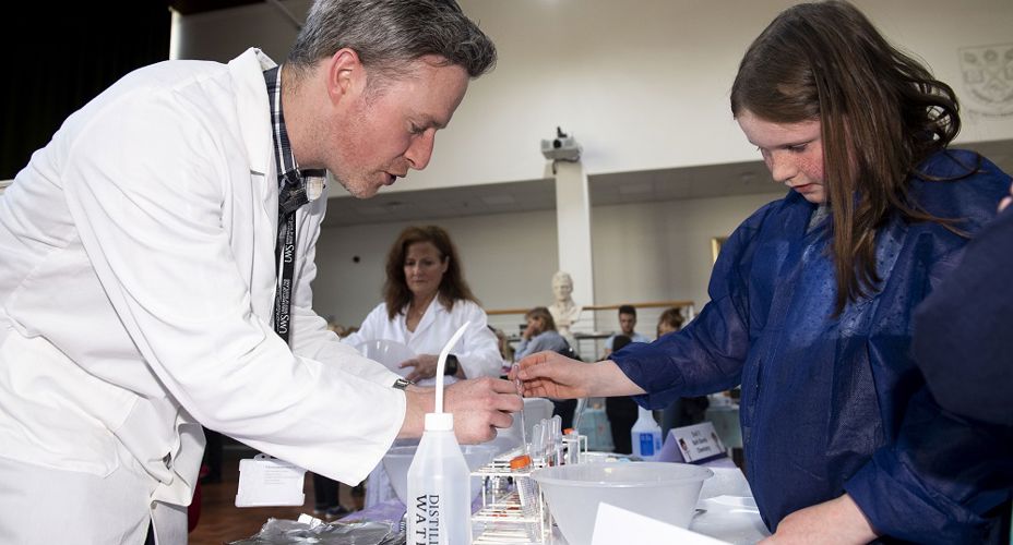 UWS staff demonstrating experiment to school pupil